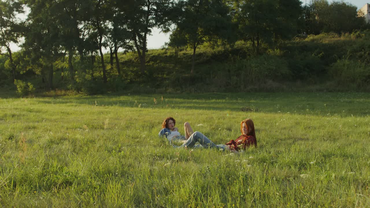 dos mujeres relajándose en un campo de hierba