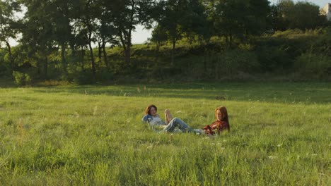 dos mujeres relajándose en un campo de hierba