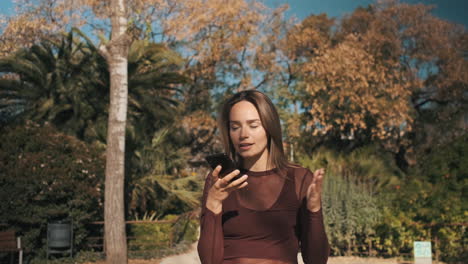 una mujer joven usando un teléfono inteligente al aire libre.