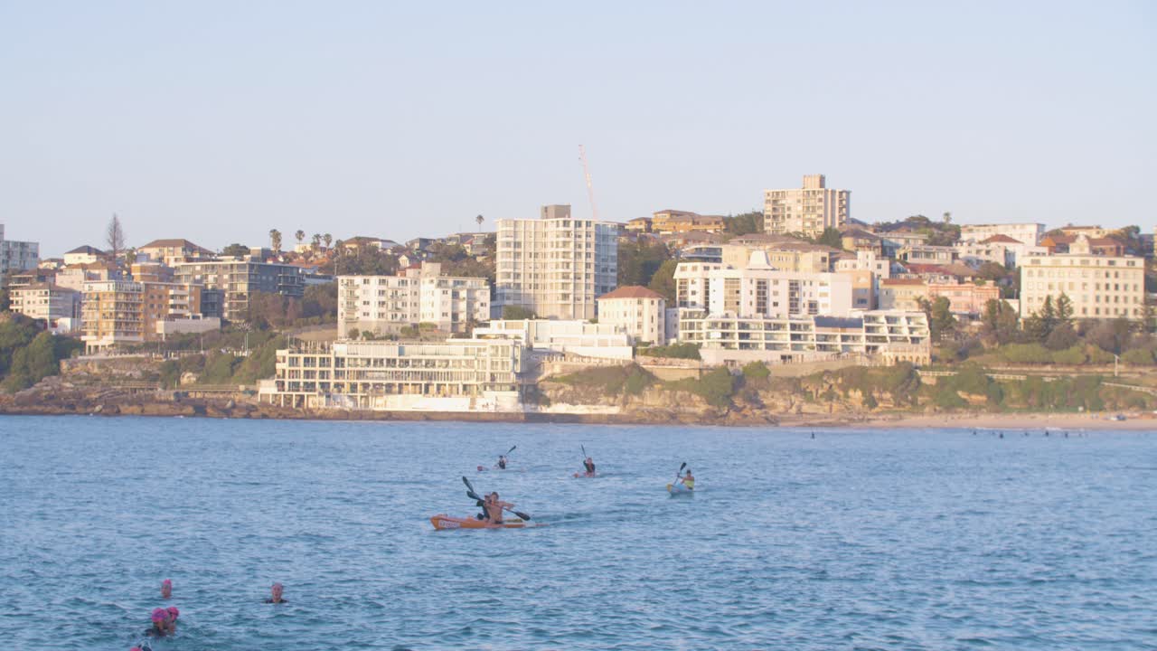 concepto de ejercicio acuático - kayakistas y nadadores afuera en la playa de north bondi en australia