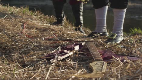 broken guitar on riverbank, historical re-enactment