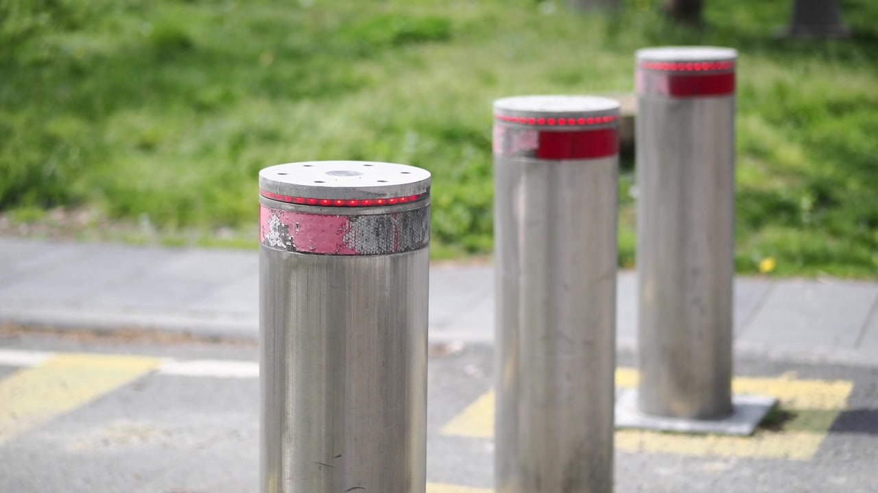 Automatiska infällbara metallpollare som reser sig på en stadsgata