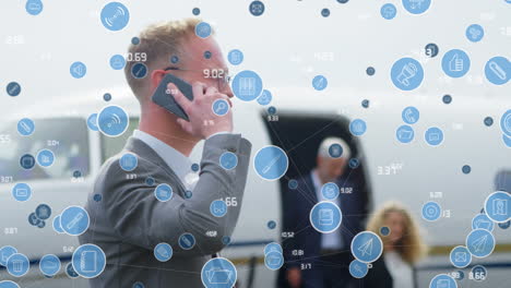 animation of icons over caucasian businessman with smartphone and private plane