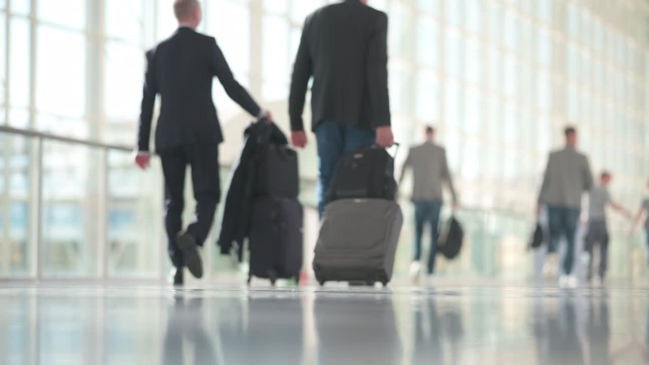 슬로우 모션으로 걷는 비즈니스 복장의 여성, 백그라운드에서 가방을 든 남자