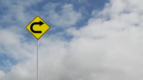 animation of yellow road sign with black arrow over sky in the background.