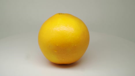 Frische-Orangefarbene-Früchte,-Die-Sich-Im-Drehteller-Mit-Weißem-Hintergrund-Drehen-Und-Drehen---Nahaufnahme