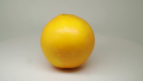 fresh orange fruits rotating and spinning in the turntable with white background - close up shot