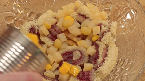 adding fruit over a layer of jelly rolls in an english trifle