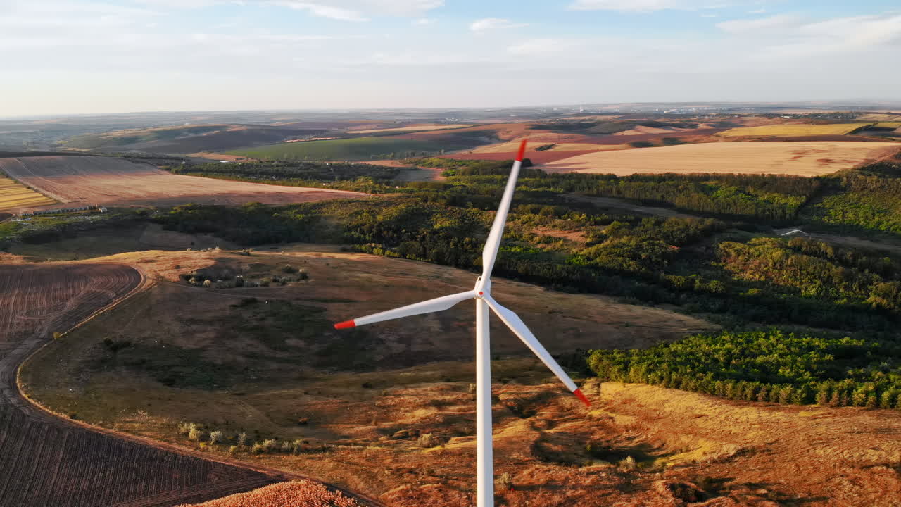 Aerial drone view of wind turbines for energy production located on a field at sunset. Windmill's power generating clean renewable energy for sustainable development. Balti, Moldova