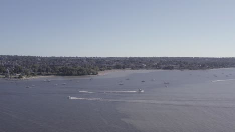 Sobrevuelo-Aéreo-Desde-La-Bahía-Inglesa-Hasta-La-Playa-De-Kitsilano-En-Un-Caluroso-Día-De-Verano-Mientras-Los-Navegantes-Se-Relajan,-Broncean,-Disfrutan-De-La-Actividad-En-La-Playa,-Los-Botes-A-Motor-Se-Deslizan-Por-Las-Velas,-La-Fiesta,-La-Diversión-Romántica,-La-Pesca-En-El-Océano-Tropical-4-7