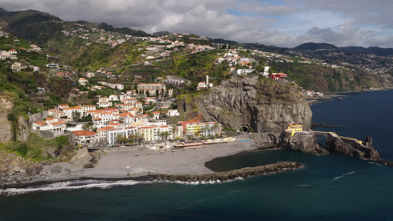 Vista Aerea di una Pittoresca Cittadina Costiera con Spiaggia e Scogliere.
