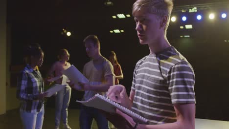 students preparing before a high school performance in an empty school theater