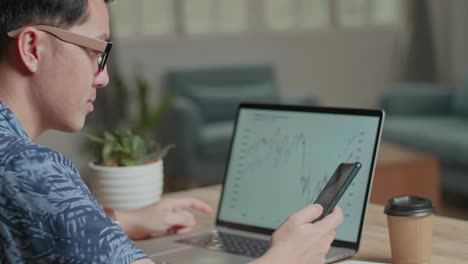 business man talking on phone during work with laptop computer at home, video in 4k