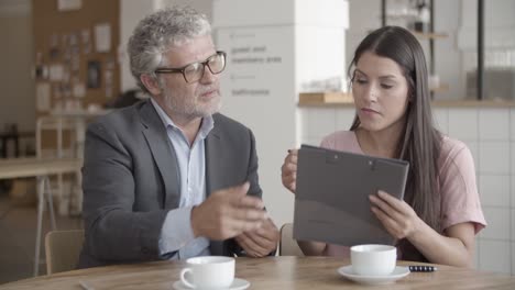 hombre de negocios barbudo profesional que muestra puntos de documento al cliente