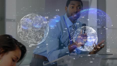 Animation-of-data-processing-with-globes-over-diverse-business-people-working-at-office