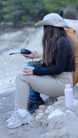 two people resting outdoors, interacting with a container