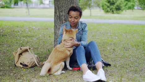 woman petting her dog in a park