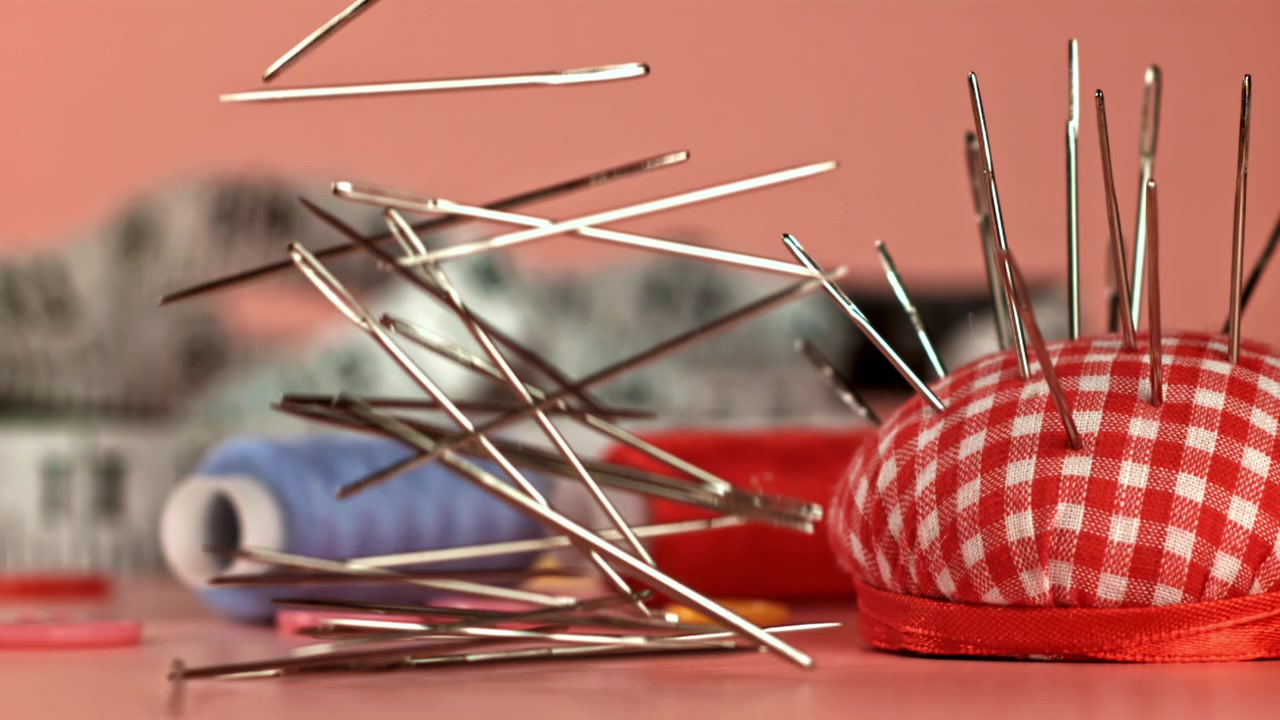 Slow Motion of Sewing Needles Dropping onto a Craft Table