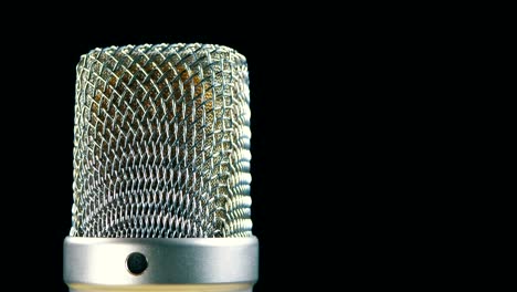 studio condenser microphone rotates on a black background