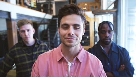 Portrait-Of-Smiling-Multi-Cultural-Male-Sales-Team-In-Fashion-Store-In-Front-Of-Clothing-Display