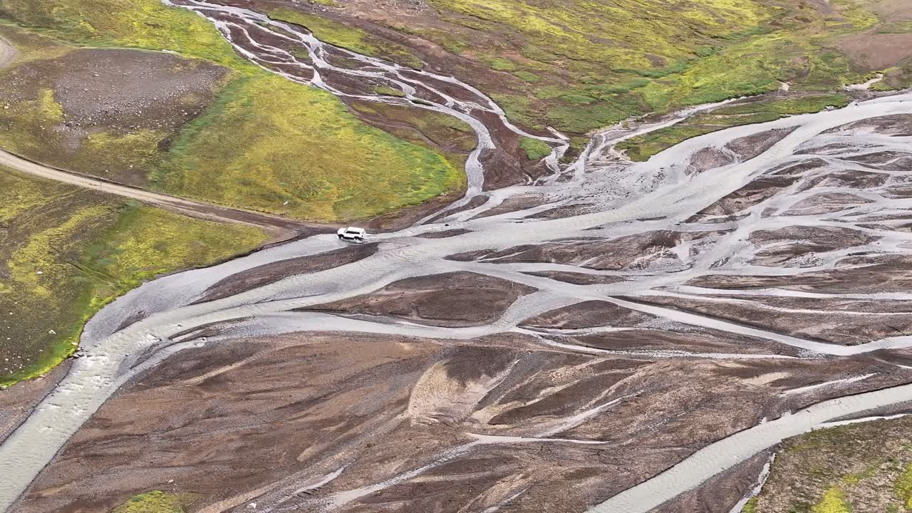 Car Driving Through A Braided River In Nyjidalur, Iceland. - aerial shot