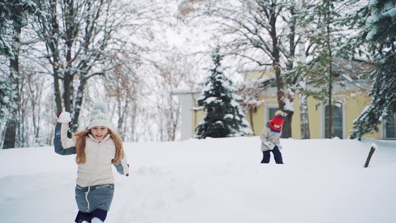 Children play catch-up in winter. Christmas Holidays. Children's games in a beautiful snowy winter park on Christmas day
