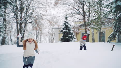 children play catch-up in winter. christmas holidays. children's games in a beautiful snowy winter park on christmas day