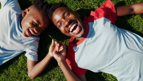 happy young boys laughing and playing on green grass