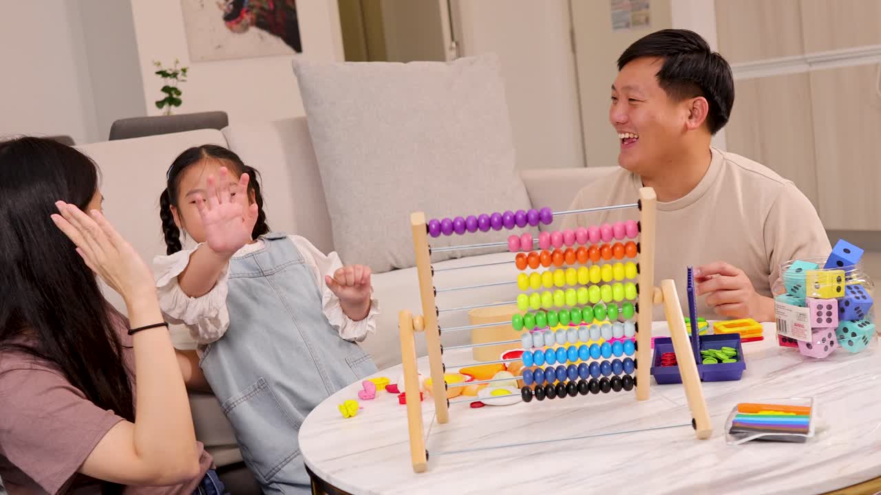 A family enjoys playful learning with a colorful abacus, fostering connection and joy in a bright, cozy living room