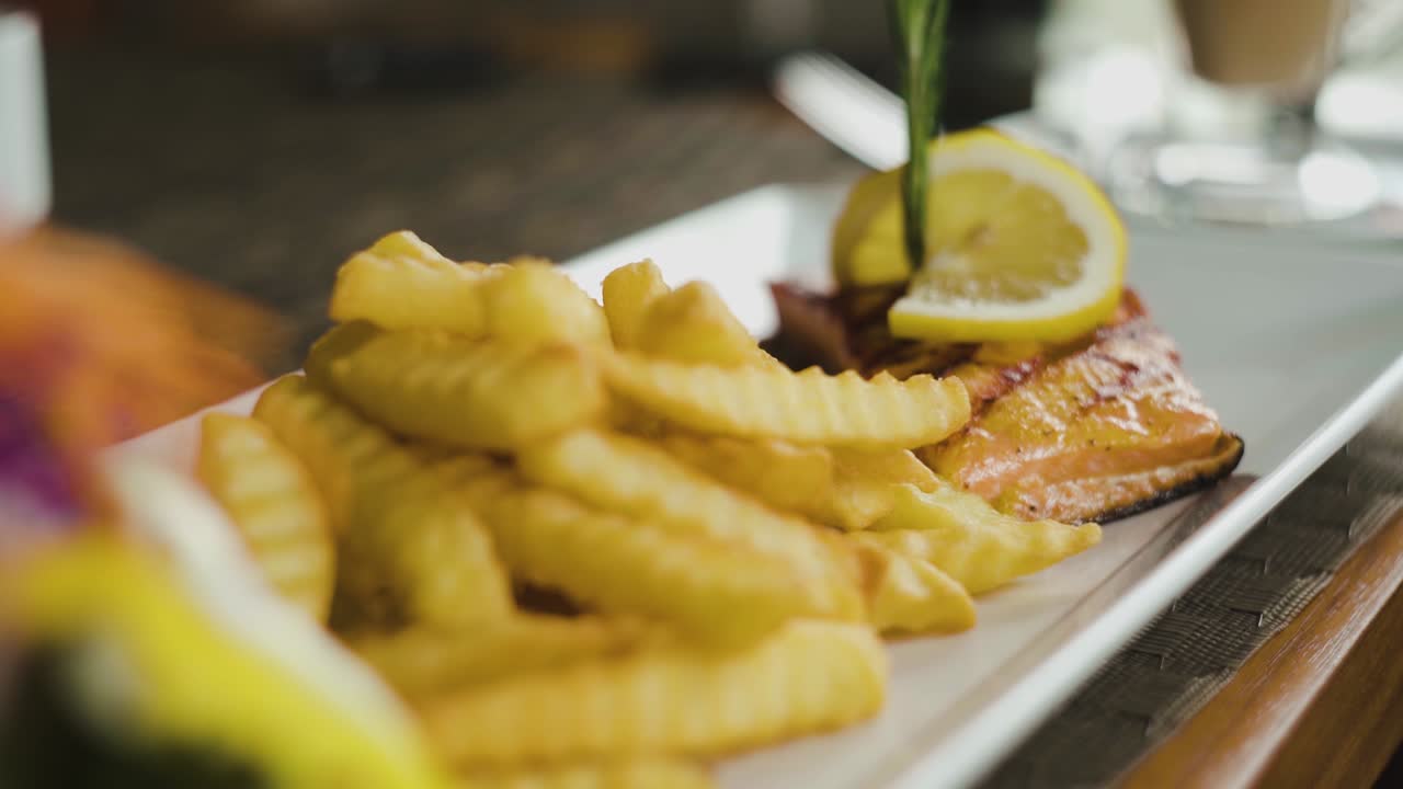 Laksefilet med pommes frites ved siden av, statisk nærbilde med langsom utzooming.