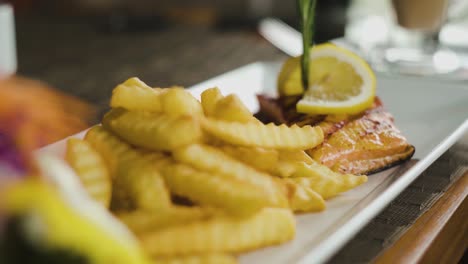 Salmon-steak-with-french-fries-on-side-close-up-static-shot-with-slow-zoom-out