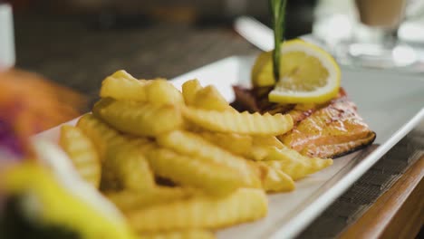 salmon steak with french fries on side close up static shot with slow zoom out