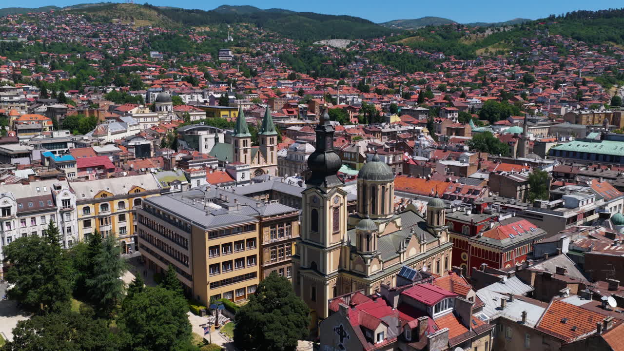 Panoramic View Of Sarajevo's Old Town With Churches, Mosques, And Red-roofed Houses On Sunny Day. aerial panning shot