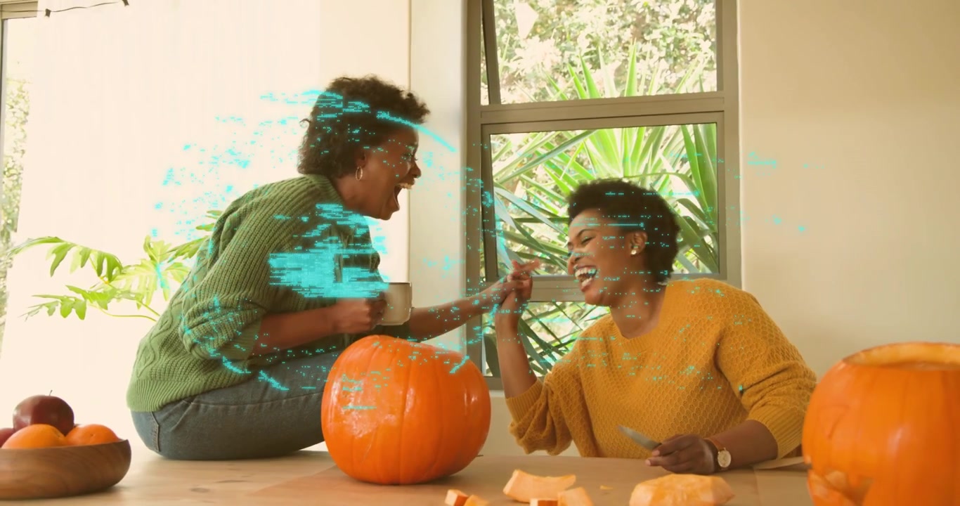 Mustard sweater woman carving pumpkin as green-clad friend laughing and teal tech padlock pulsing