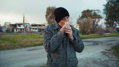 Old Man Blowing His Nose with a Tissue in the Winter Park