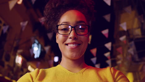 smiling woman in glasses at night