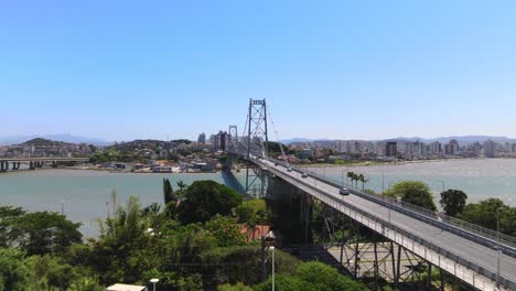 escena aérea de drones del puente hercílio luz con gran complejo urbano de la ciudad capital florianópolis con puente colgante metálico puesta de sol con puente y centro de urbanismo