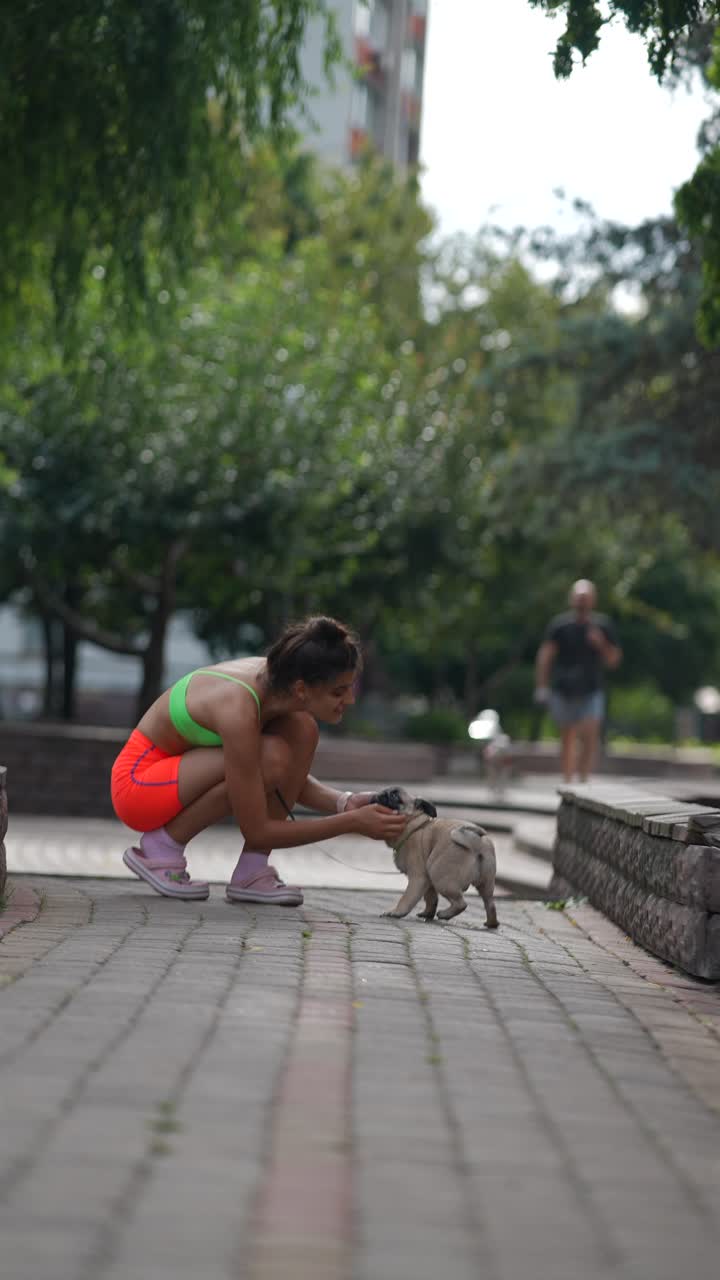 una mujer con su perro pug en un parque