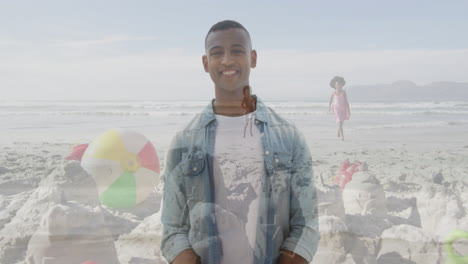at beach, man with colorful beach ball, smiling with people in background