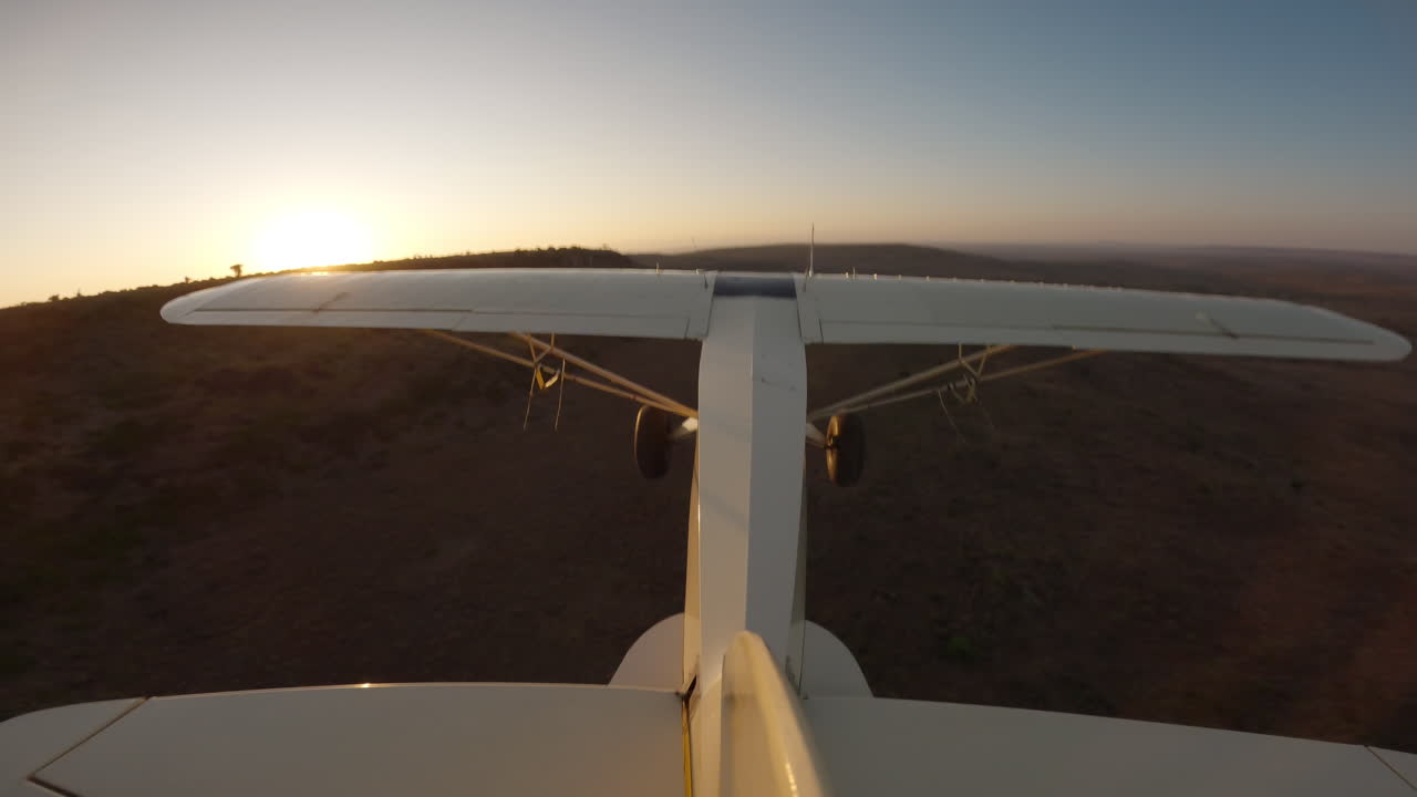 Aereo da bushcraft in volo sopra le colline al crepuscolo nella savana