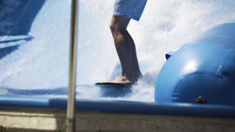 close up on man's feet as he struggles to balance while surfing a wave machine