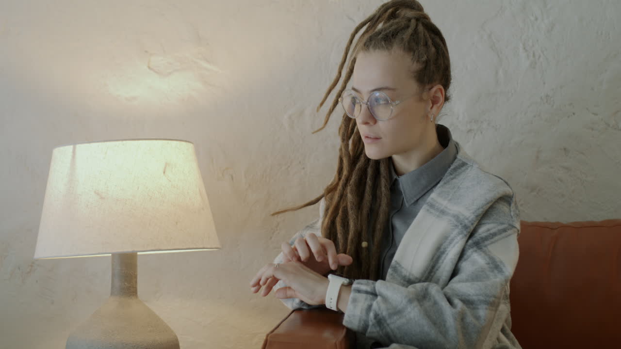 Woman Checking Smartwatch on Couch