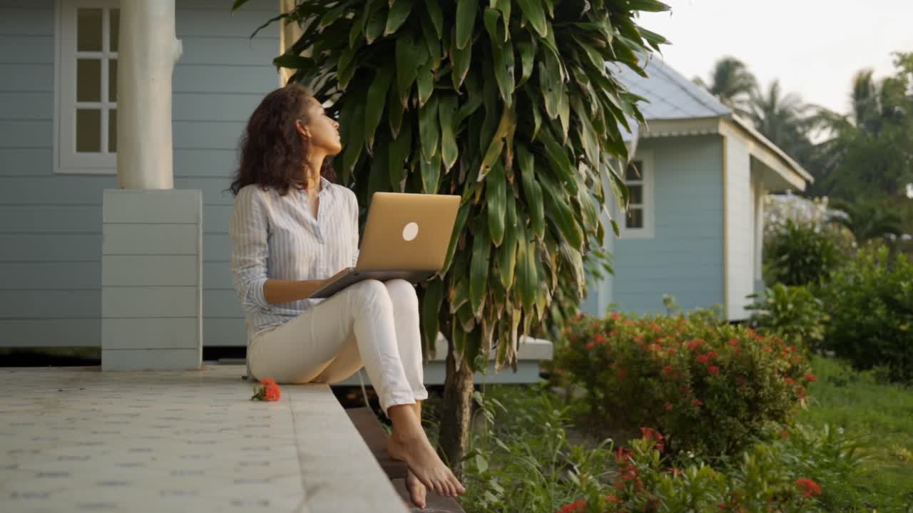 Woman working on laptop on a porch