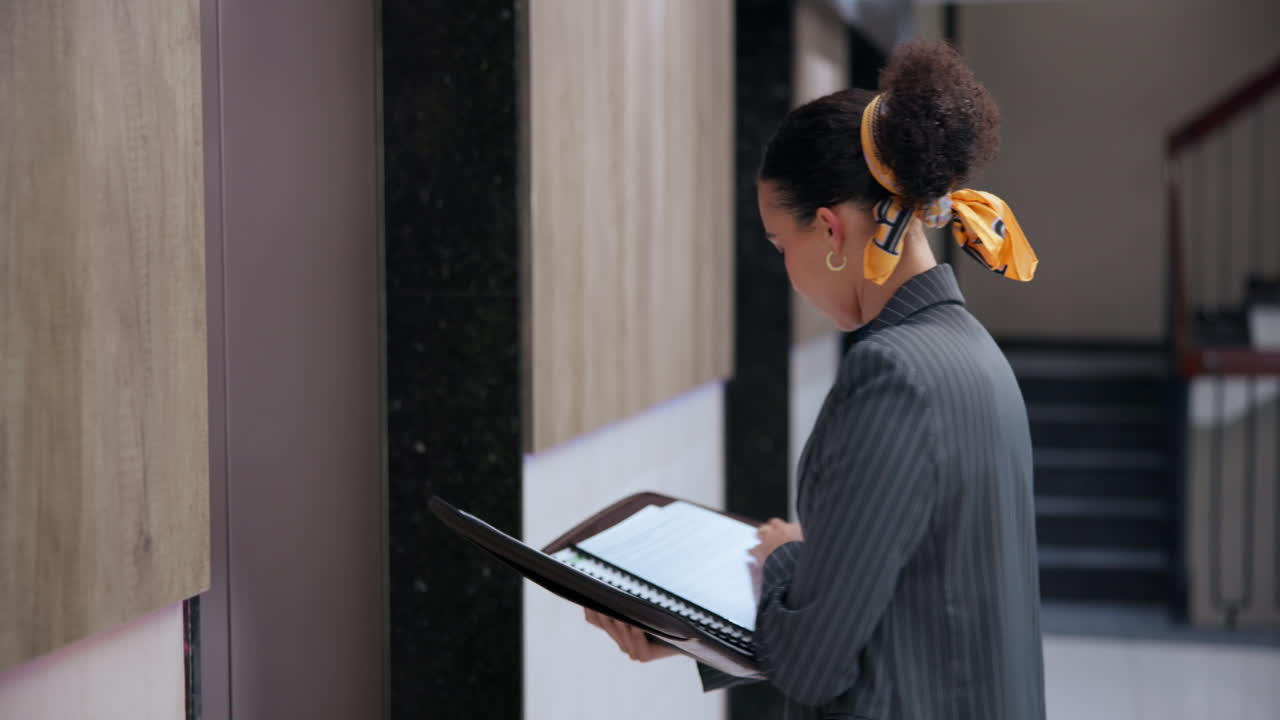 Businesswoman reading documents near an elevator