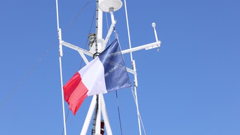 french flag waving on a ship's mast