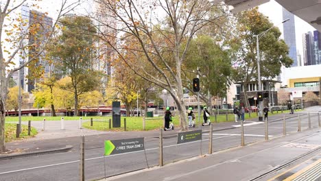 personas cruzando la calle cerca del parque y los edificios