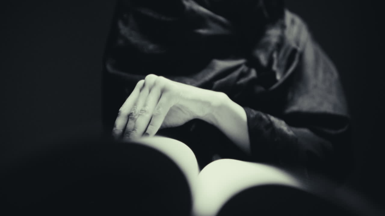 Donna che legge un libro con un mantello scuro