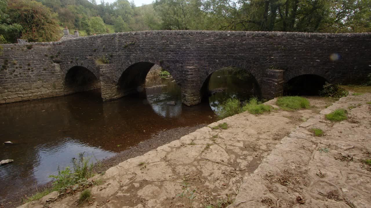 Veduta ampia del ponte in pietra a Wetton Mill, con vista a est.
