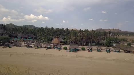 Resort-palm-trees-and-sun-beds-Wonderful-aerial-view-flight-slider-fly-sideways-from-right-to-left-drone-footage-Pantai-Kuta-Lombok-Indonesia-Cinematic-view-from-above-Tourist-Guide-by-Philipp-Marnitz