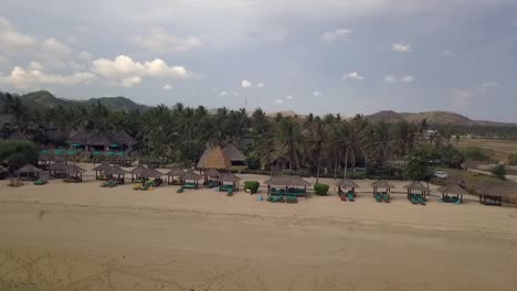 resort palmeras y tumbonas maravillosa vista aérea control deslizante de vuelo volar de lado de derecha a izquierda imágenes de drones pantai kuta lombok indonesia vista cinematográfica desde arriba guía turística por philipp marnitz